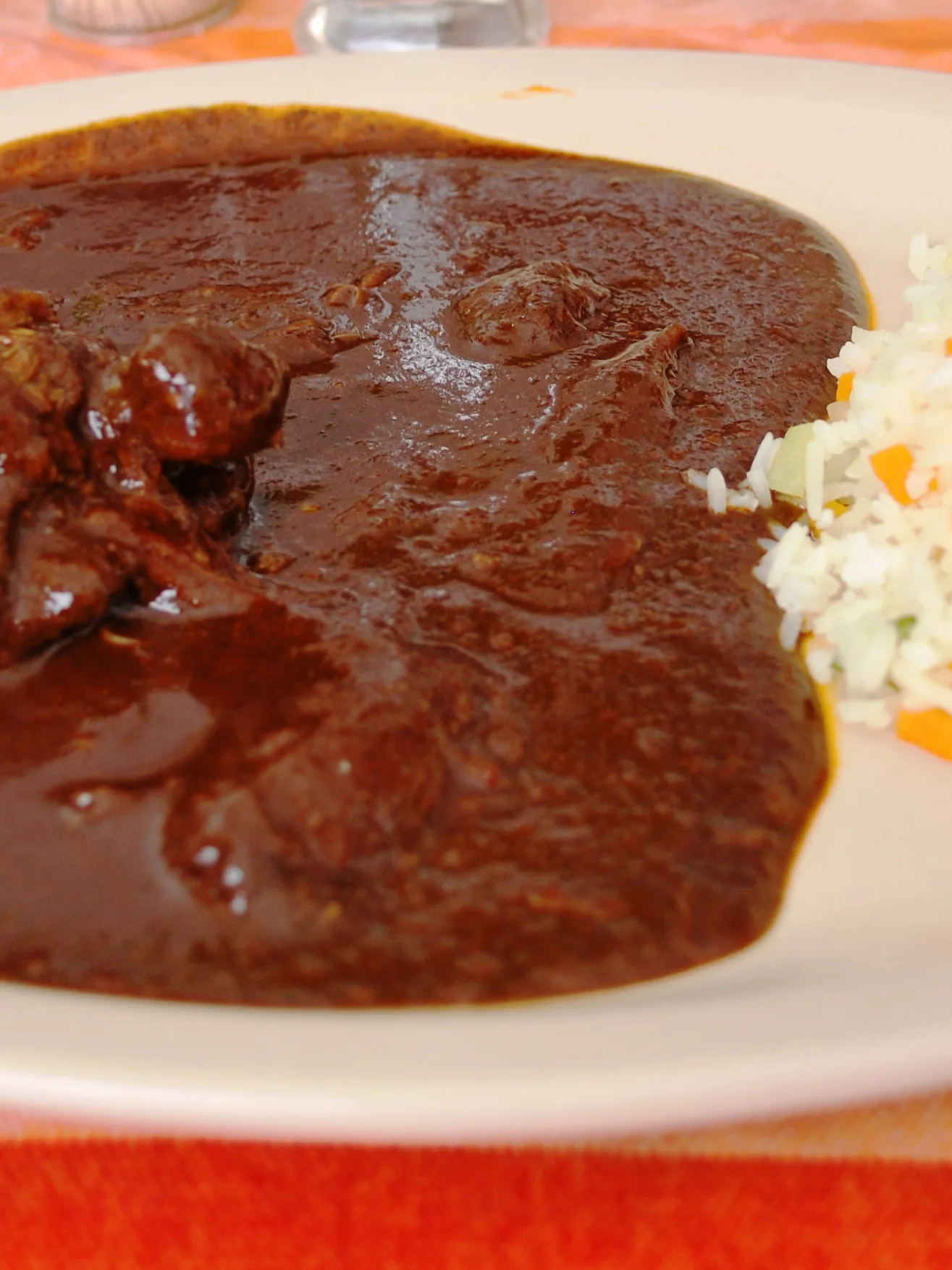 chimole: Chicken thigh in red mole sauce served with rice. At a restaurant in Taxco de Alarcón, Guerrero, Mexico