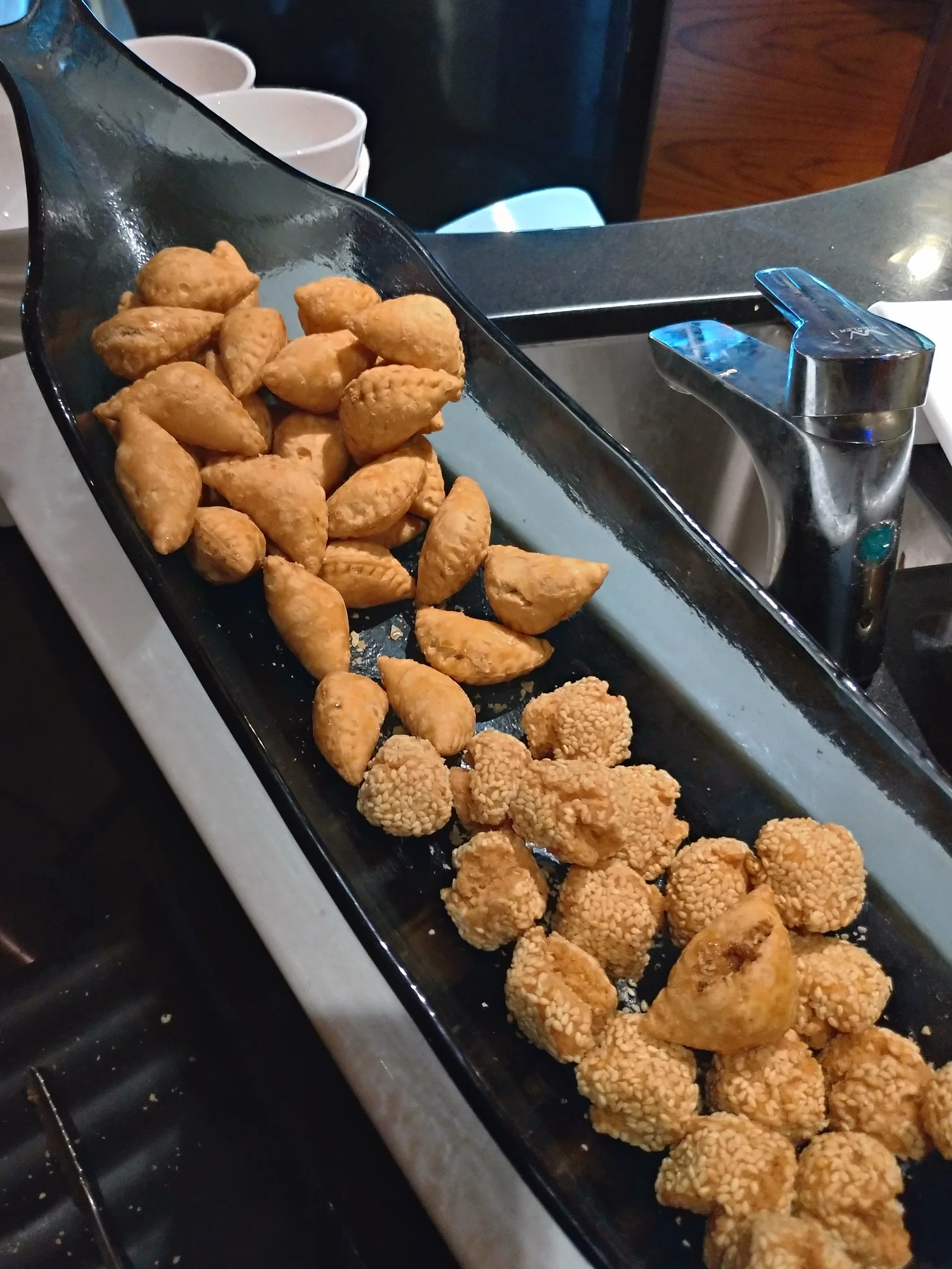 Zhimazao: A plate of yau gokes and sesame cookie balls was provided by club house in Hong Kong