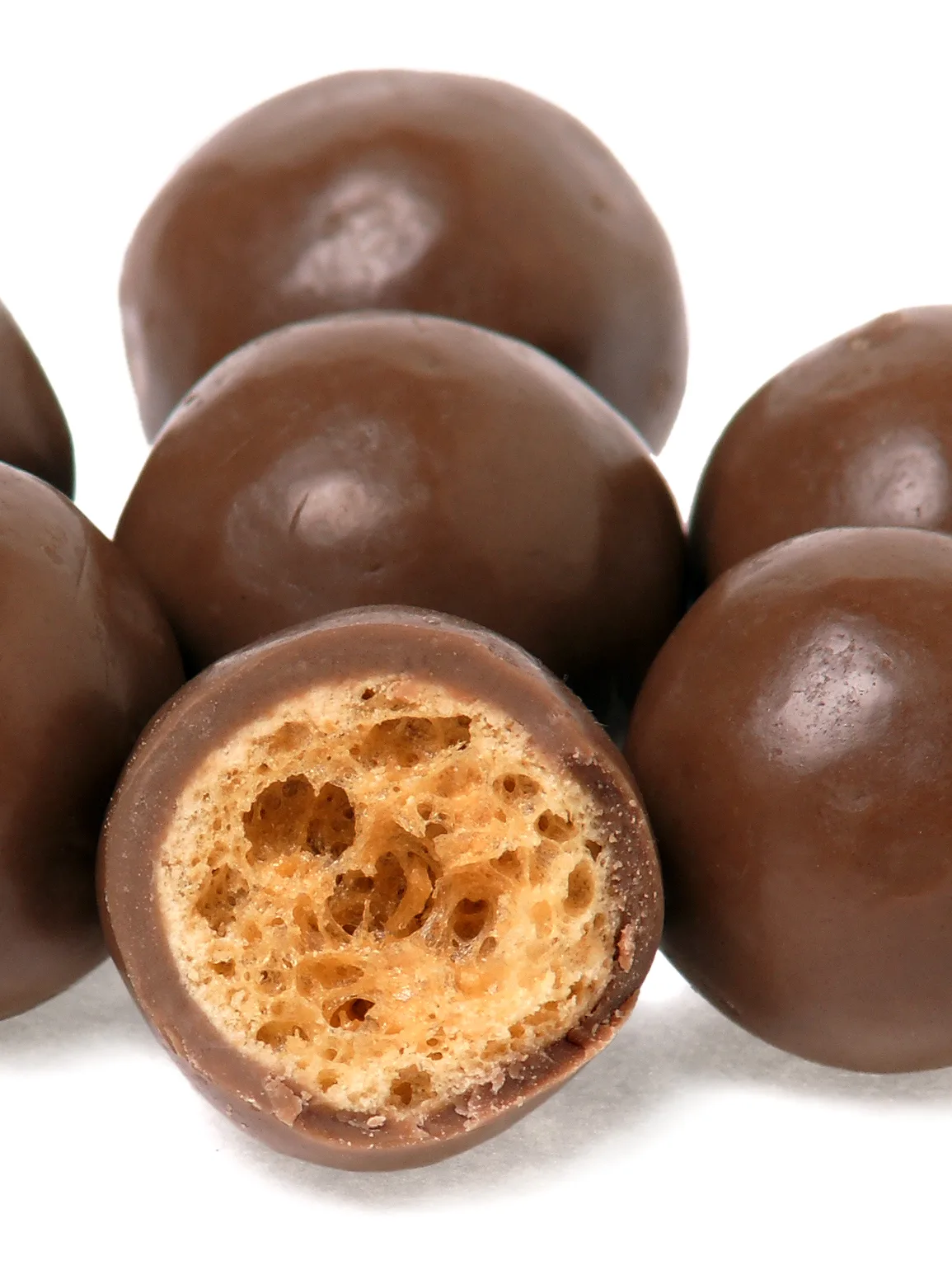 Maltesers: A pile of Maltesers candies and one split in half