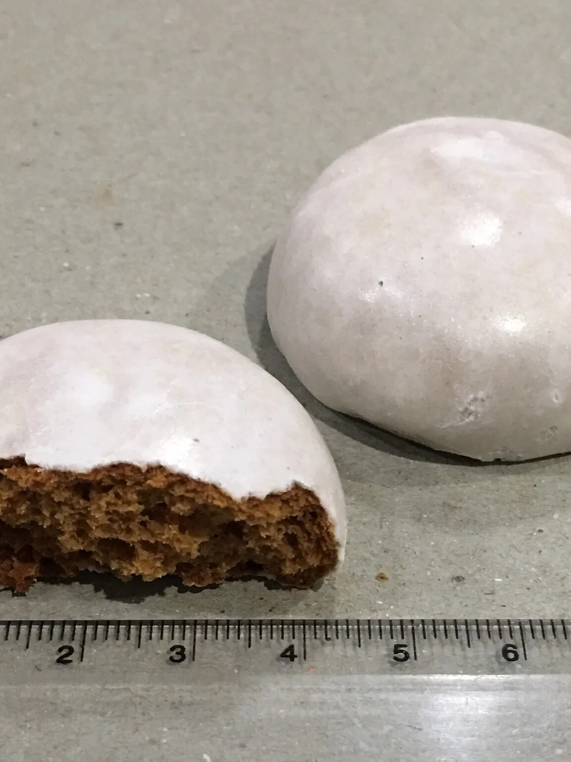 pfeffernusse: One and a half pfeffernüsse commercially manufactured (in Germany), sold in Australia. With centimetre ruler for scale