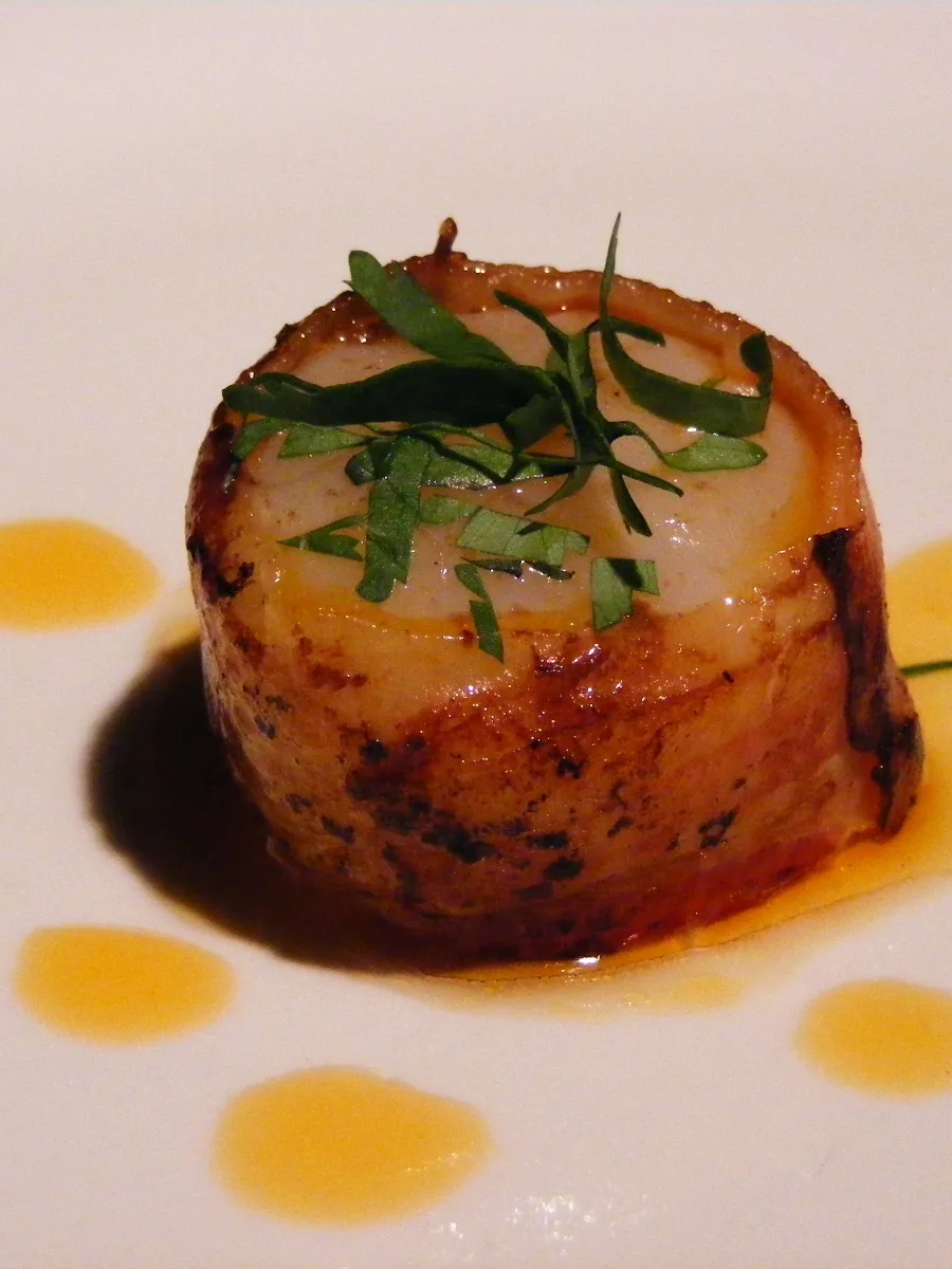 Zeeuws spek: Scallop wrapped with Zeeuws Spek, a Dutch bacon, and pan fried. Infused with chili pepper oil